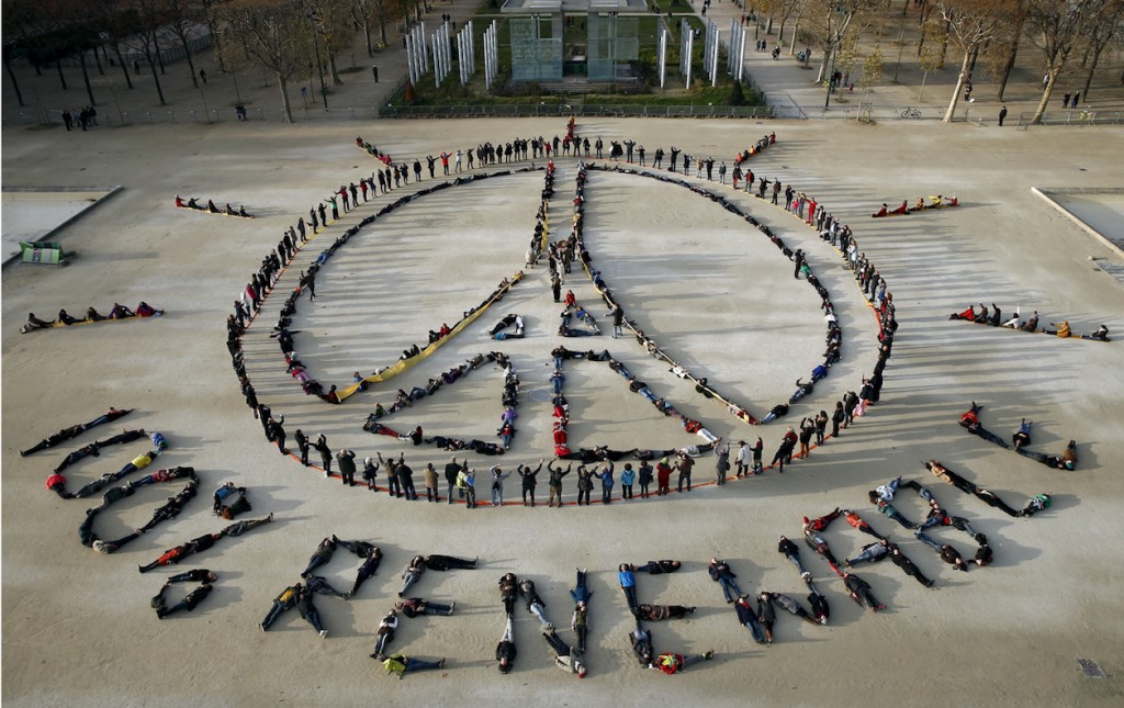 Hundreds of environmentalists arrange their bodies to form a message of hope and peace in front of the Eiffel Tower in Paris, France, December 6, 2015, as the World Climate Change Conference 2015 (COP21) continues at Le Bourget near the French capital. REUTERS/Benoit Tessier - RTX1XF6Y